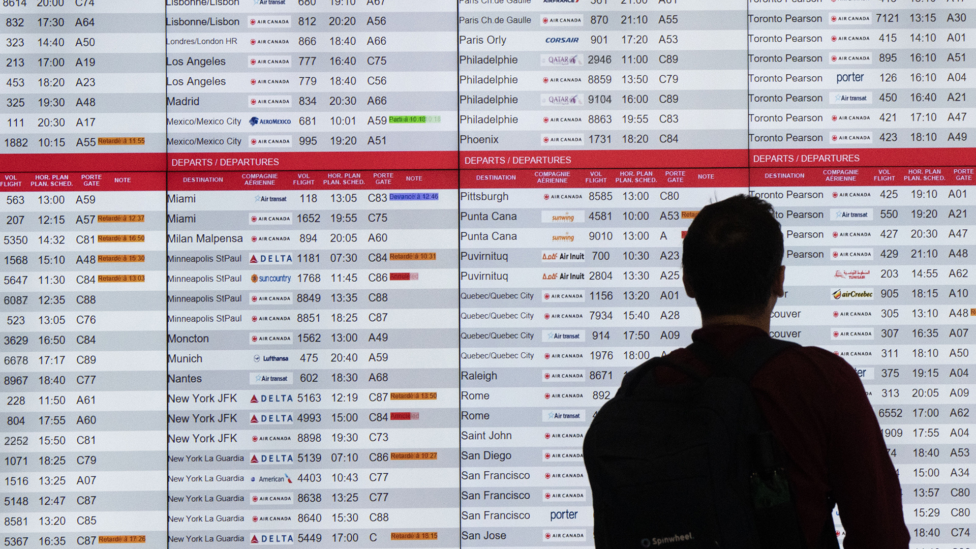 Un homme scrute un tableau de l'horaire des vols à l'aéroport Montréal-Trudeau, le 19 juillet 2024.