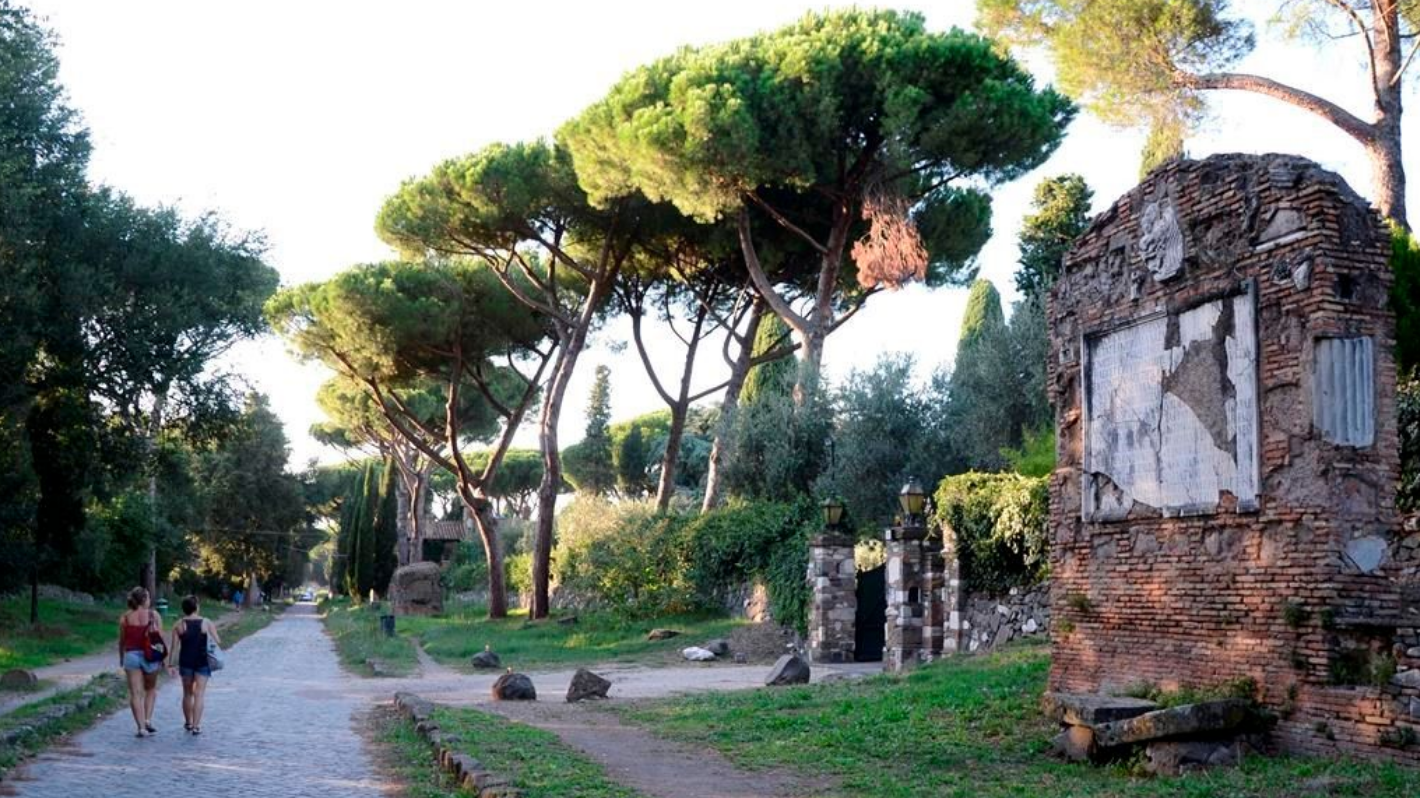 Des personnes marchent devant des ruines le long de l'Appia Antica, l'ancienne voie romaine Appienne, à Rome, le 7 septembre 2013. 