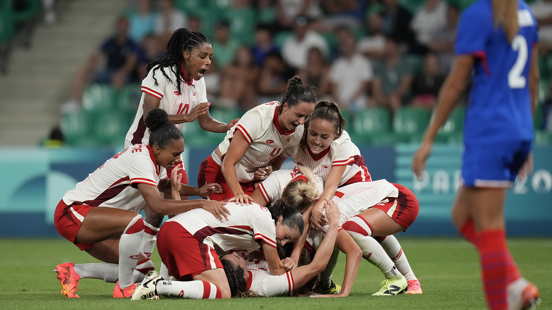 Les joueuses du Canada célèbrent après que Vanessa Gille, en bas au centre, a marqué le deuxième but de son équipe lors du match de football féminin du groupe A entre le Canada et la France au stade Geoffroy-Guichard pendant les Jeux olympiques d'été de 2024, dimanche 28 juillet 2024, à Saint-Étienne, en France.