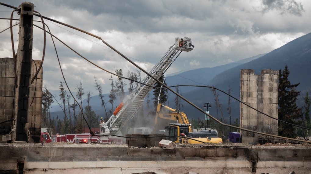 Des équipes de pompiers s'efforcent d'éteindre les points chauds du Maligne Lodge à Jasper, en Alberta, le 26 juillet 2024.