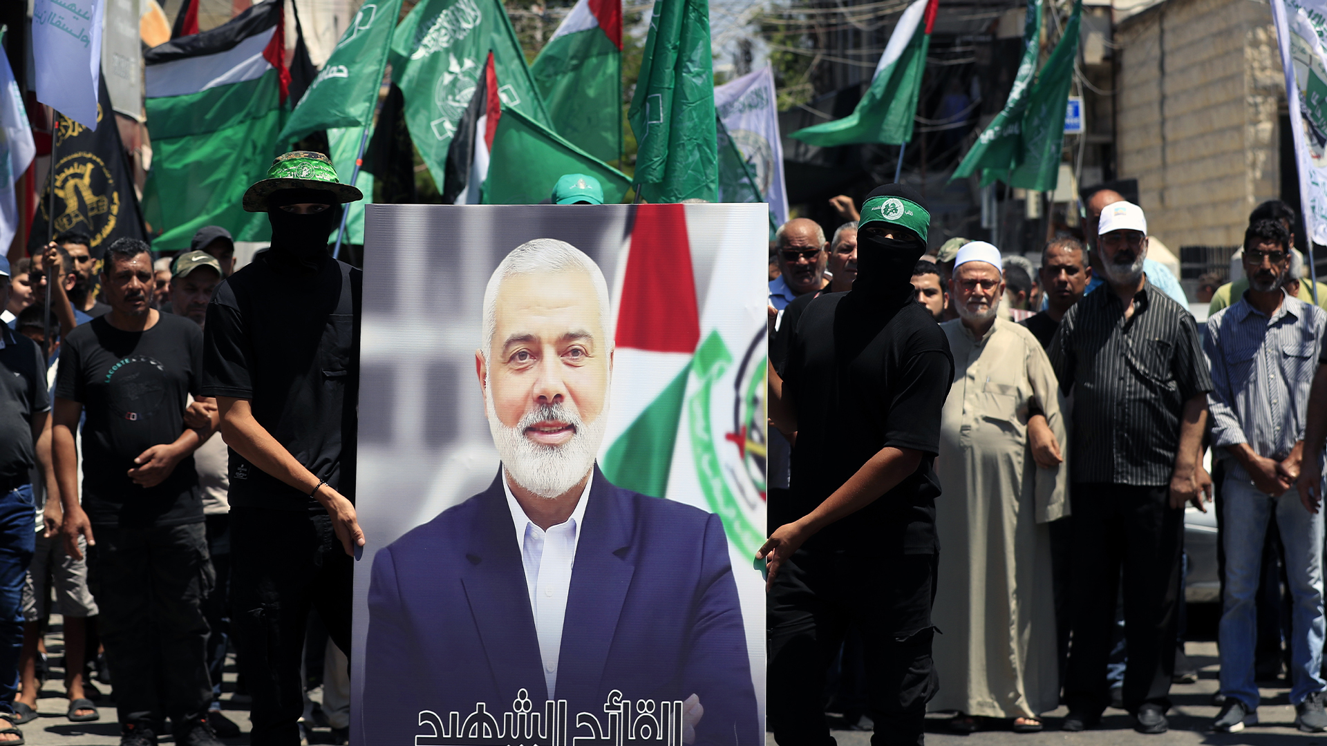 Des membres du Hamas tiennent une affiche du chef politique du Hamas, Ismail Haniyeh, lors d'une manifestation visant à condamner son assassinat, dans le camp de réfugiés palestiniens d'al-Bass, au sud du Liban, le 31 juillet.