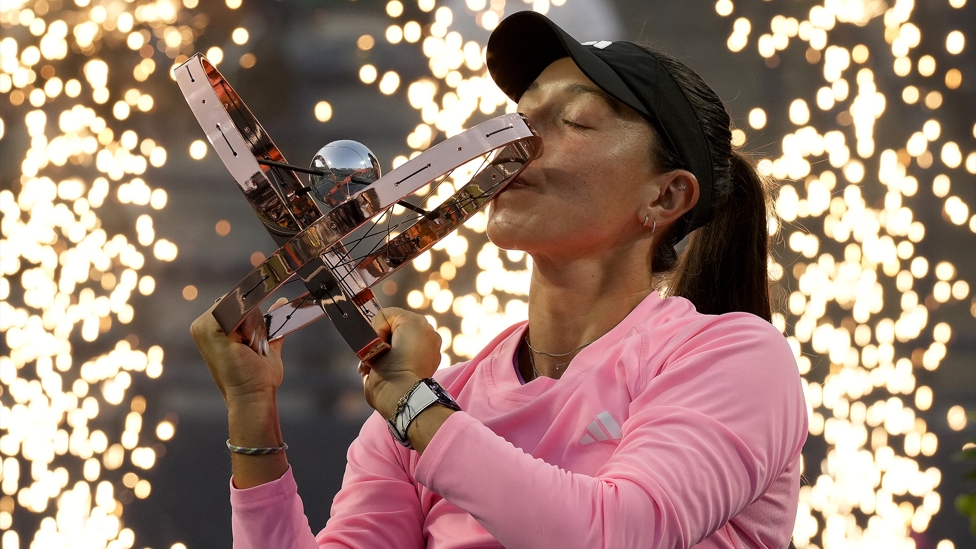 Des pièces pyrotechniques sont allumées derrière Jessica Pegula, des États-Unis, alors qu'elle embrasse son trophée après sa victoire en simple féminin à l'Omnium Banque Nationale, à Toronto, le lundi 12 août 2024.