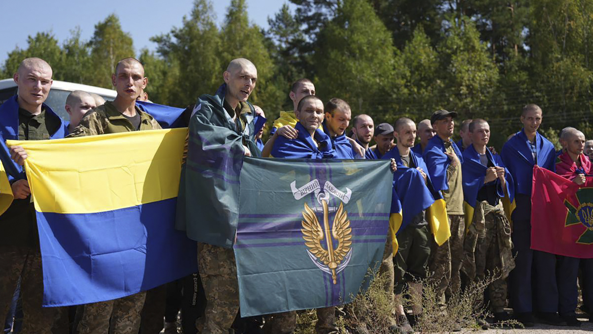 Sur cette photo, des prisonniers de guerre ukrainiens tiennent les drapeaux de leurs unités après un échange de prisonniers dans un lieu non divulgué.