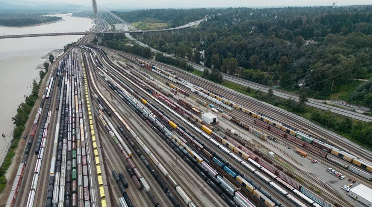 Des wagons de train sont vus sur les voies dans une vue aérienne du triage Thornton du Canadien National, alors que le pont Port Mann enjambe le fleuve Fraser, à Surrey, en Colombie-Britannique, le jeudi 22 août 2024.