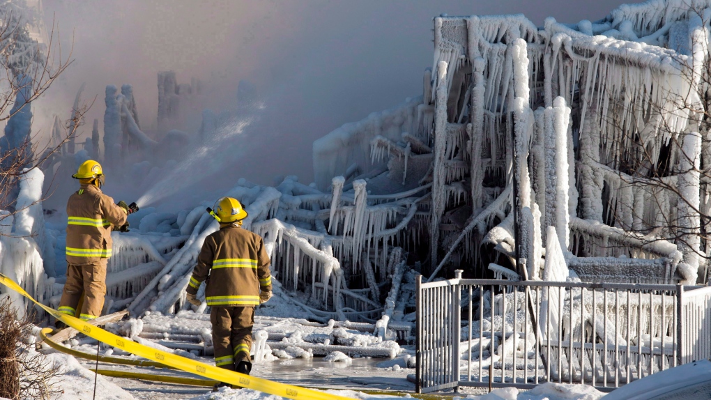 Des pompiers interviennent dans les décombres où un incendie mortel a détruit une résidence pour personnes âgées à L'Isle-Verte, au Québec, le jeudi 23 janvier 2014.