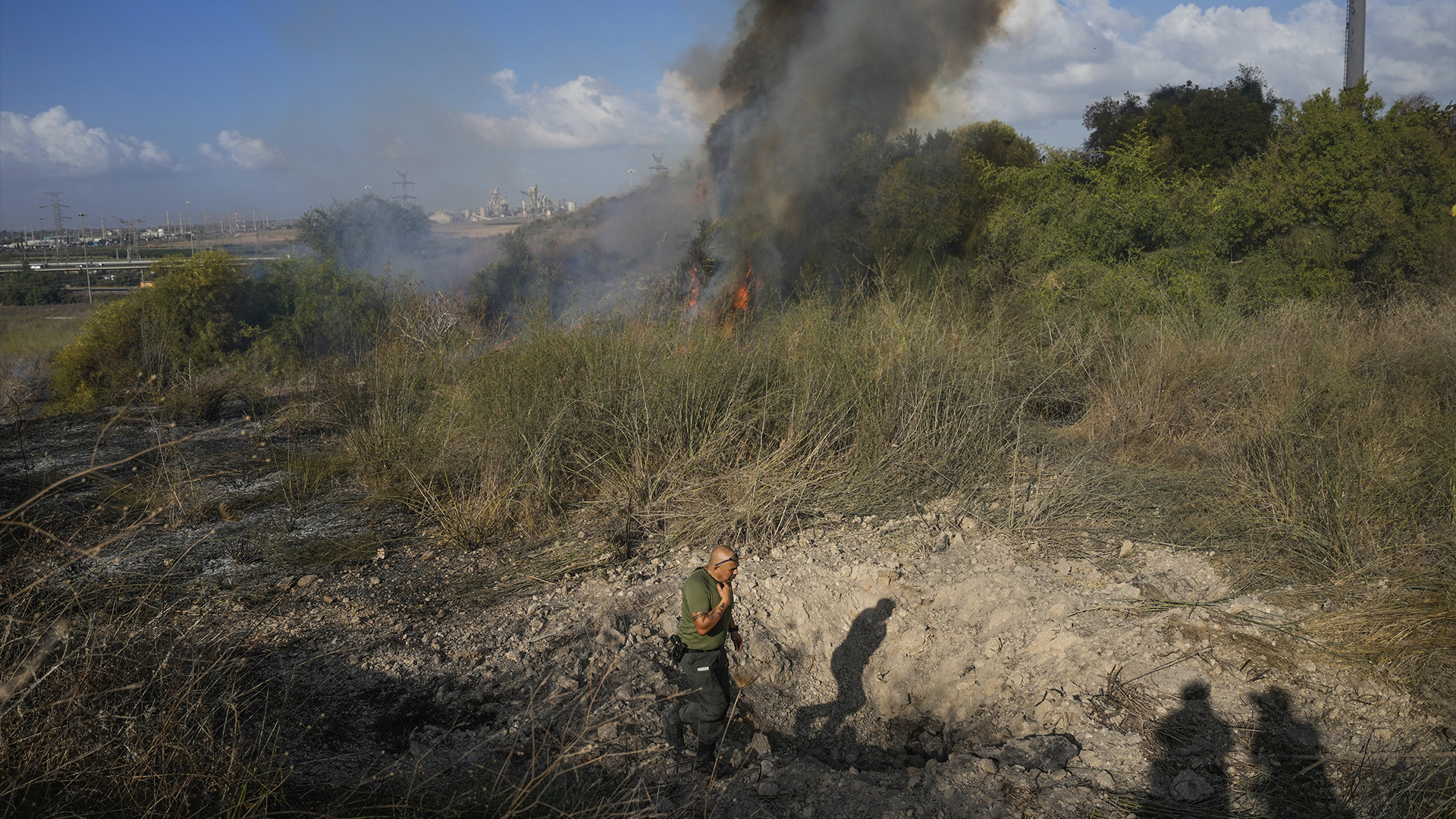 A police officer inspects the area around a fire after the military said it fired interceptors at a missile launched from Yemen that landed in central Israel on Sunday, Sept. 15, 2024.