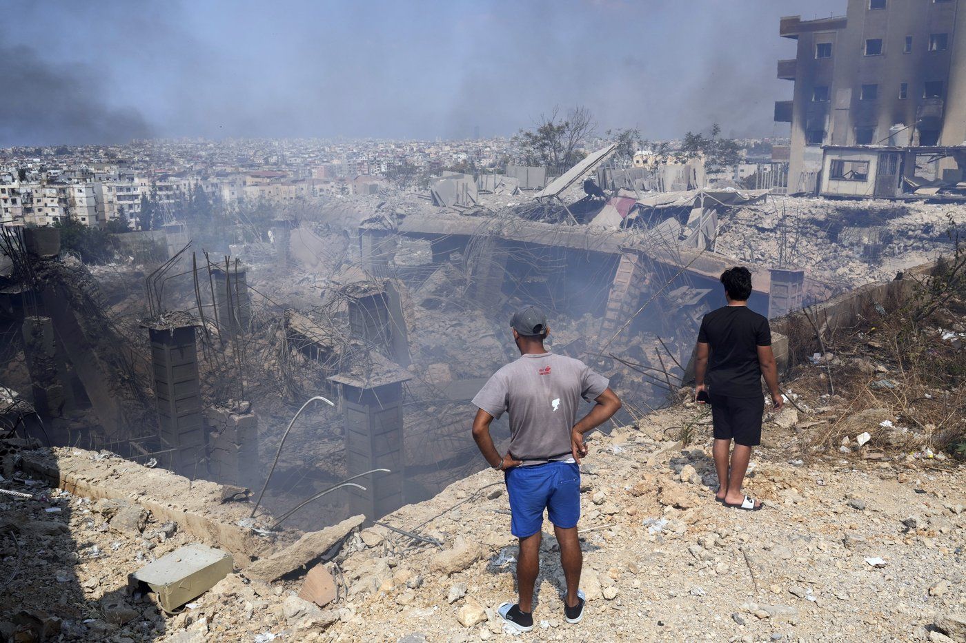 Des gens inspectent un bâtiment endommagé sur le site d’une frappe aérienne israélienne à Choueifat, au sud-est de Beyrouth, le samedi 28 septembre 2024.