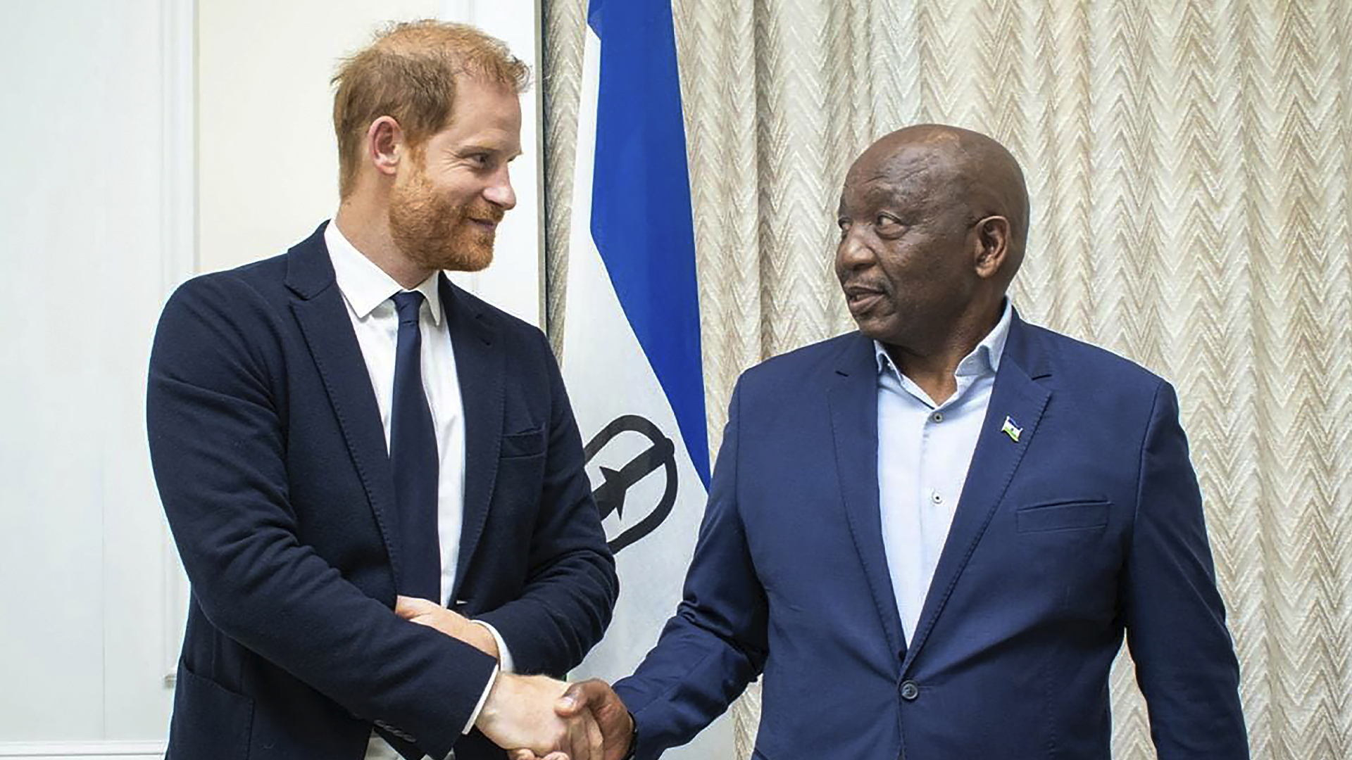 Sur cette photo fournie par le gouvernement du Lesotho, le prince Harry, à gauche, serre la main du premier ministre du Lesotho, Sam Matekane, le mercredi 2 octobre 2024, lors d'une visite dans le petit royaume montagneux où il a cofondé une organisation caritative pour la jeunesse en 2006 en l'honneur de sa défunte mère, la princesse Diana. 