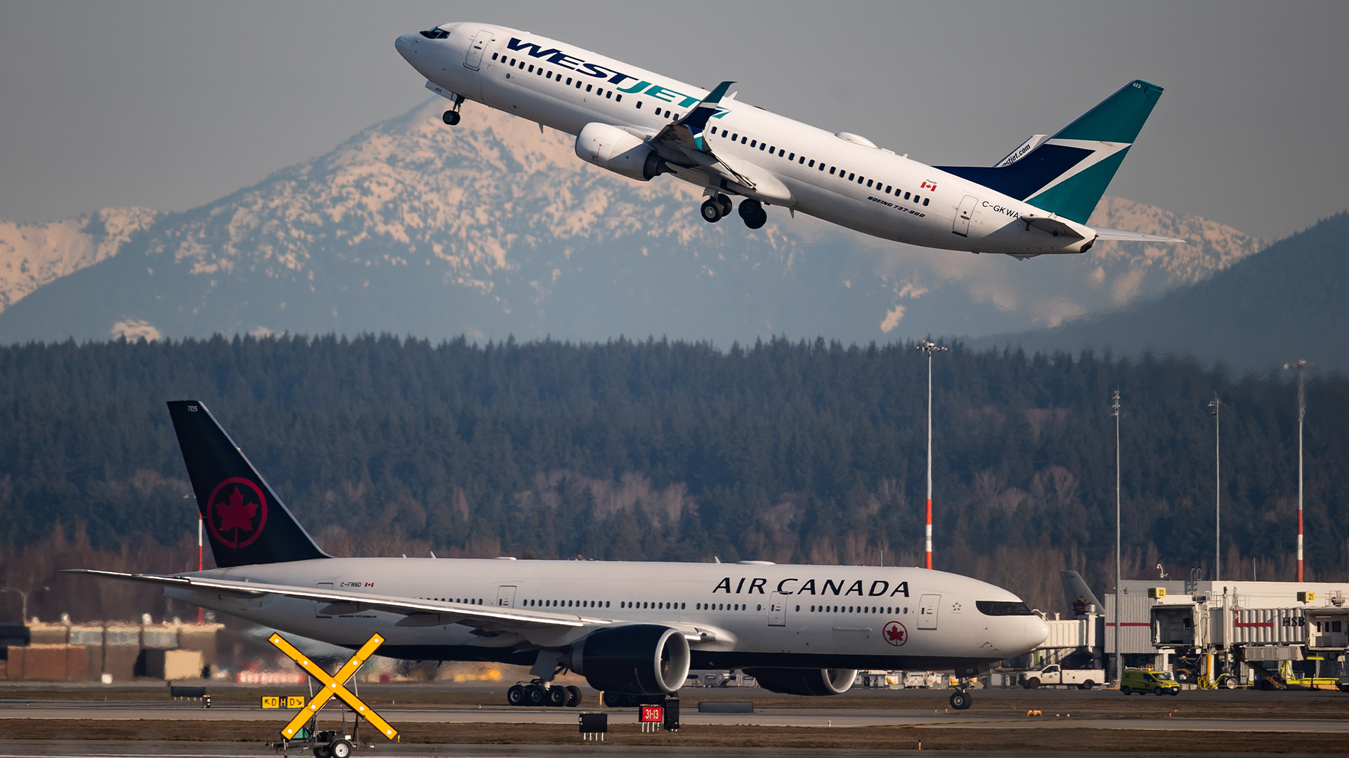 Un appareil d'Air Canada roule vers une piste tandis qu'un vol de WestJet décolle à l'aéroport international de Vancouver, à Richmond, en Colombie-Britannique, le 20 mars 2020. 