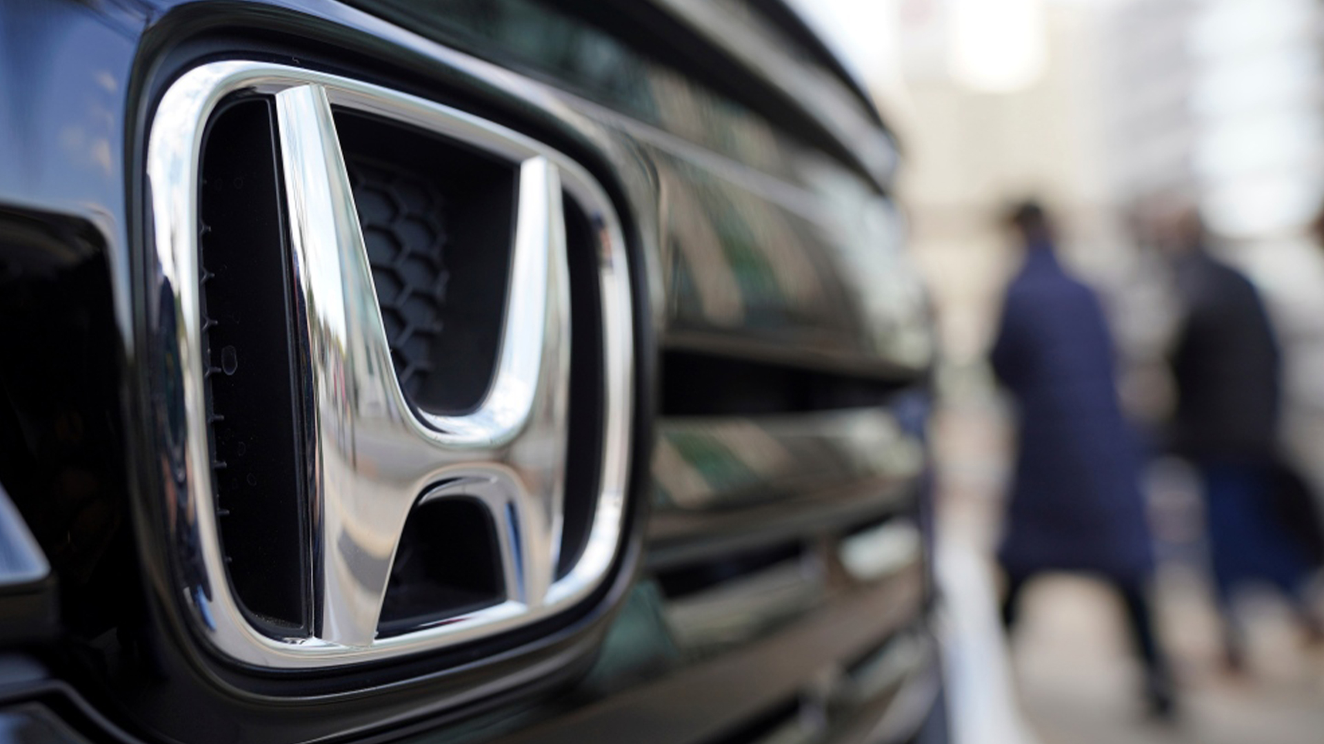 Des personnes marchent près du logo de Honda Motor Company dans une salle d'exposition, mardi 8 février 2022, à Tokyo. 