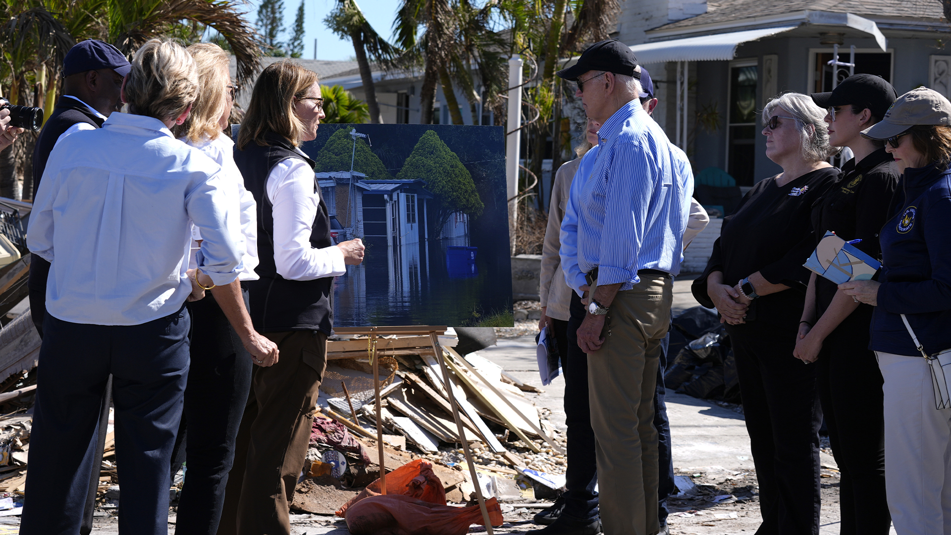 Le président Joe Biden, au centre droit, est informé par des responsables fédéraux, étatiques et locaux à St. Pete Beach, en Floride, après une visite aérienne des zones touchées par l'ouragan Milton, le 13 octobre 2024. 