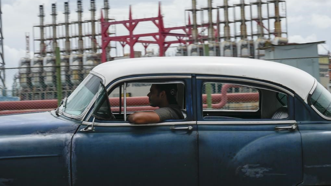 Une personne conduit une voiture américaine classique devant un générateur flottant qui ne produit pas d'électricité depuis des jours à La Havane, Cuba, le vendredi 18 octobre 2024. 