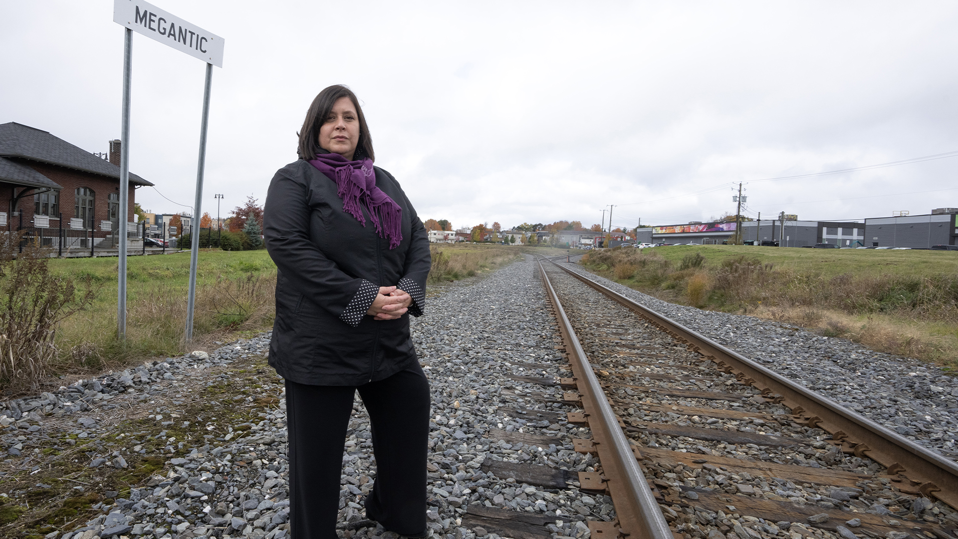 La mairesse de Lac-Mégantic, Julie Morin, se tient près de la voie qui traverse toujours le centre-ville, le mercredi 16 octobre 2024, à Lac-Mégantic. 