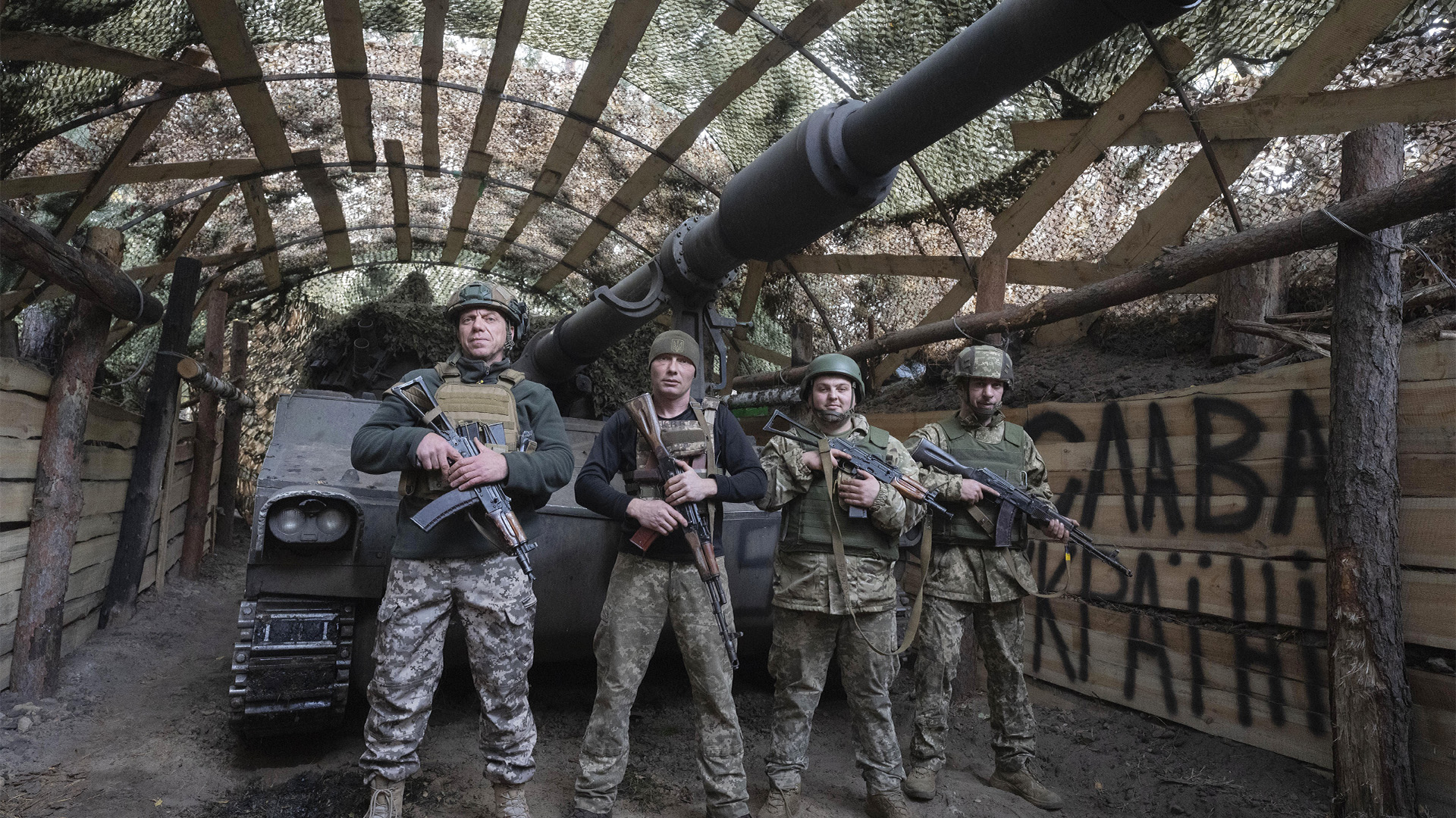 Des militaires ukrainiens de la 92e brigade d'assaut distincte posent pour une photo devant leur obusier M-109 «Paladin» de 155 mm sur la ligne de front près de Vovchansk, dans la région de Kharkiv, en Ukraine, le lundi 28 octobre 2024, avec un panneau en arrière-plan indiquant «Gloire à l'Ukraine». 