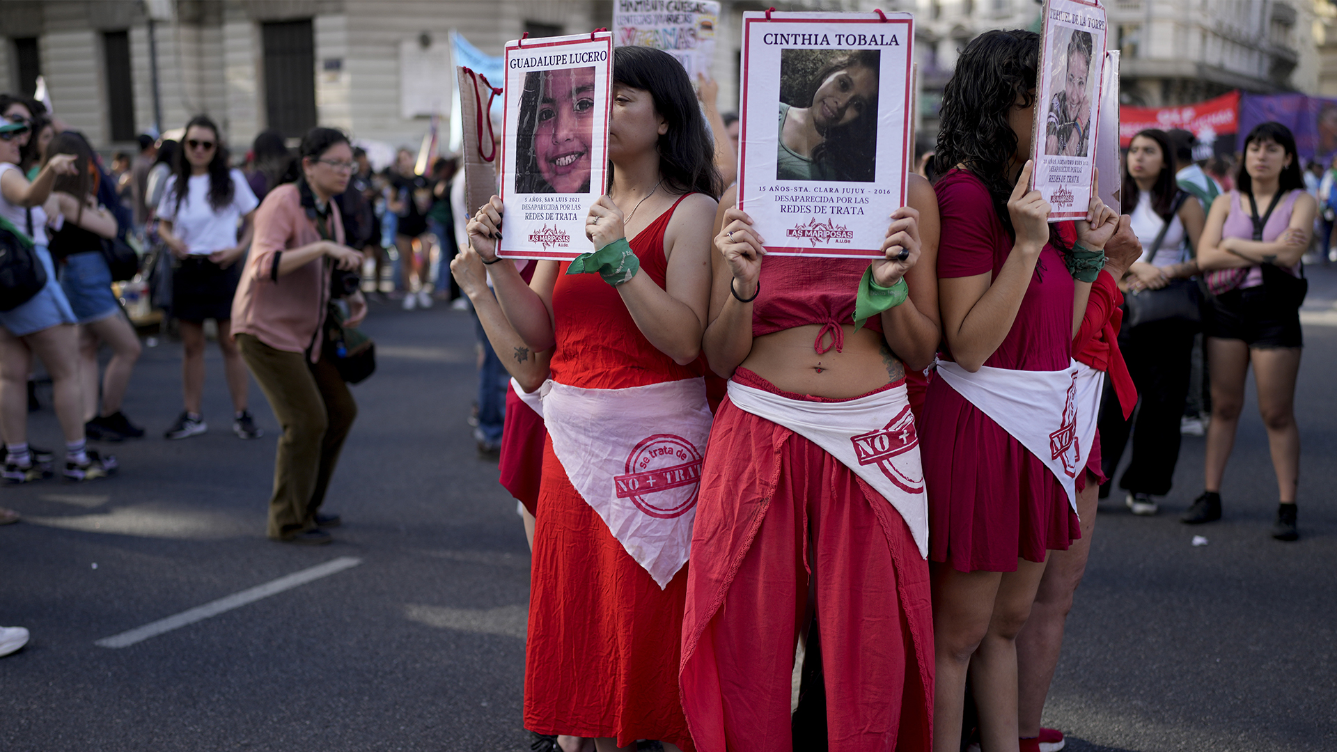 Des manifestants tiennent des photos de victimes de la traite des êtres humains lors d'une manifestation marquant la Journée internationale pour l'élimination de la violence à l'égard des femmes, à Buenos Aires, en Argentine, le samedi 25 novembre 2023.