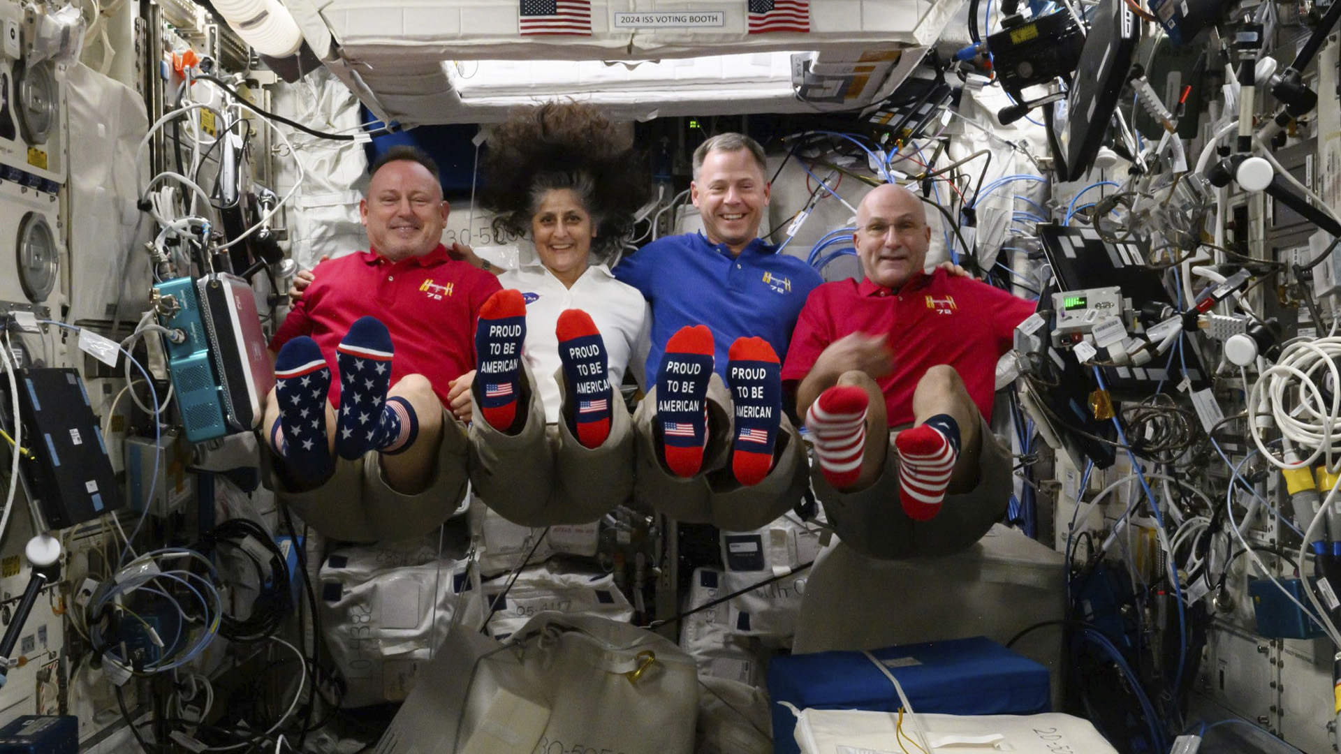 Sur cette photo fournie par la NASA, de gauche à droite, les astronautes Butch Wilmore, Suni Williams, Nick Hague et Don Pettit montrent leurs chaussettes à l'effigie du drapeau américain à bord de la Station spatiale internationale (SSI) le jour de l'élection, le mardi 5 novembre 2024. 