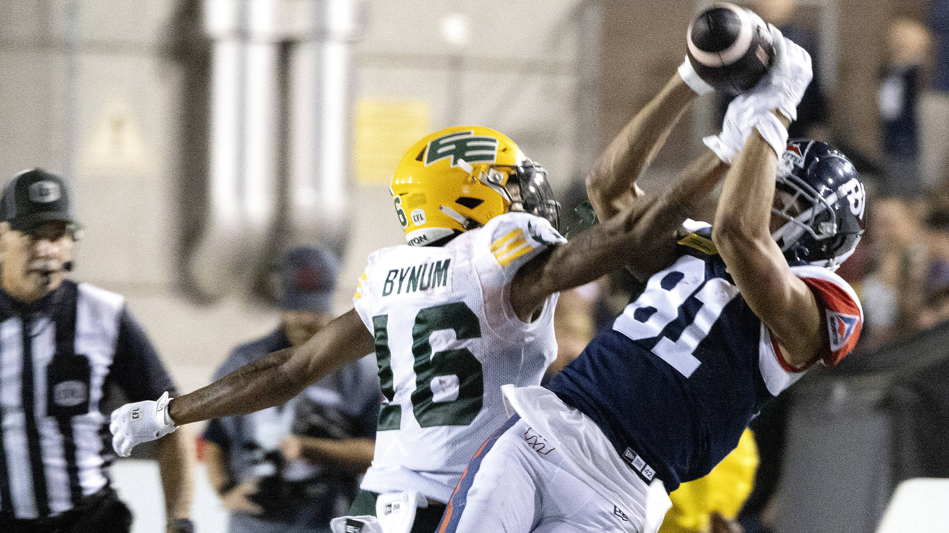 Le receveur des Alouettes de Montréal Austin Mack (81) effectue un attrapé, mais tombe sur les lignes de côté devant le joueur des Elks d'Emonton Devodric Bynum (16) lors d'un affrontement disputé le 25 août 2024, à Montréal.