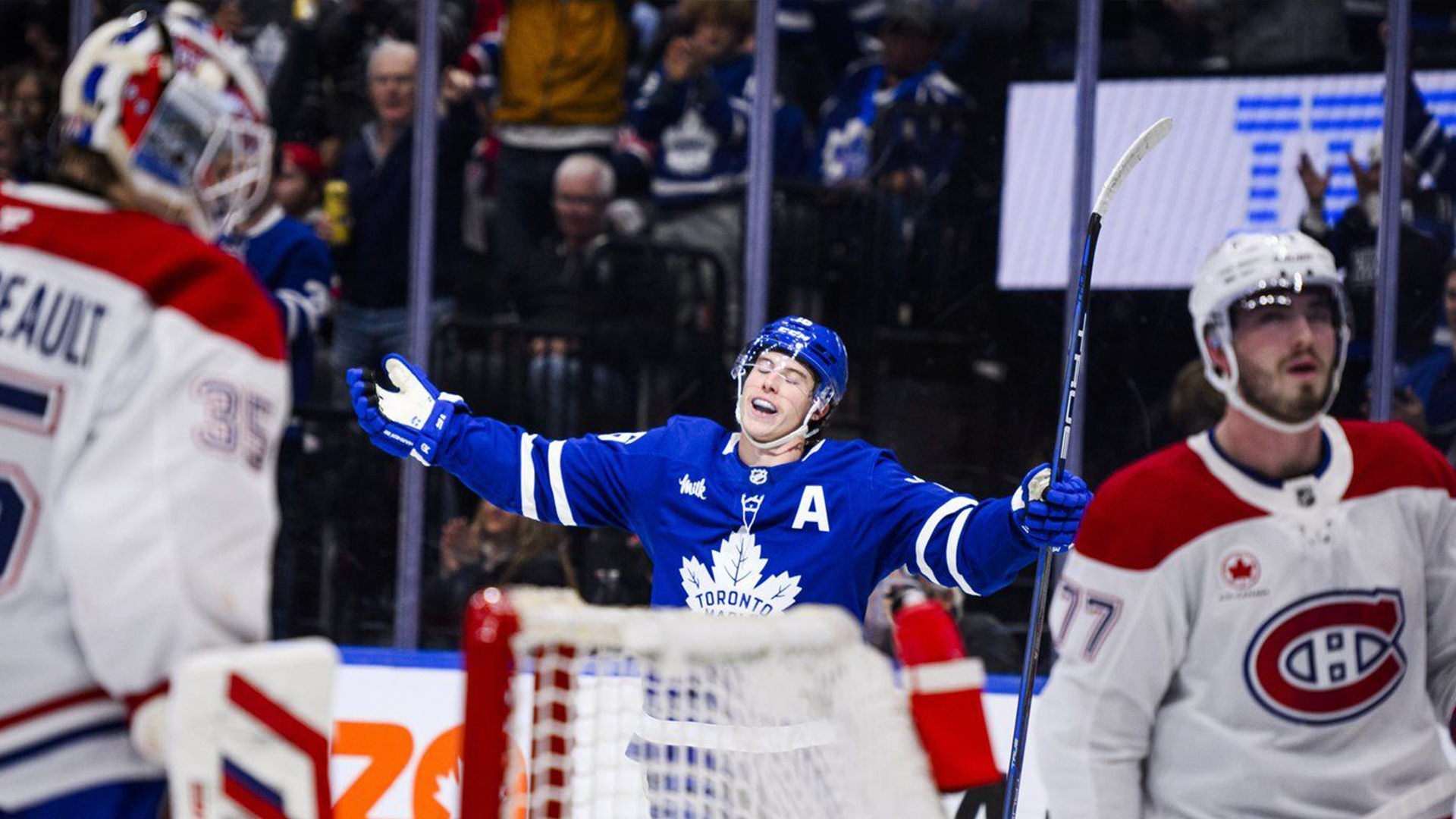 Mitch Marner (au centre), des Maple Leafs de Toronto, célèbre son but tandis que le gardien Samuel Montembeault (35) et l'attaquant Kirby Dach (77), du Canadien de Montréal, regardent durant la deuxième période d'un match de hockey de la LNH, le samedi 9 novembre 2024, à Toronto. 