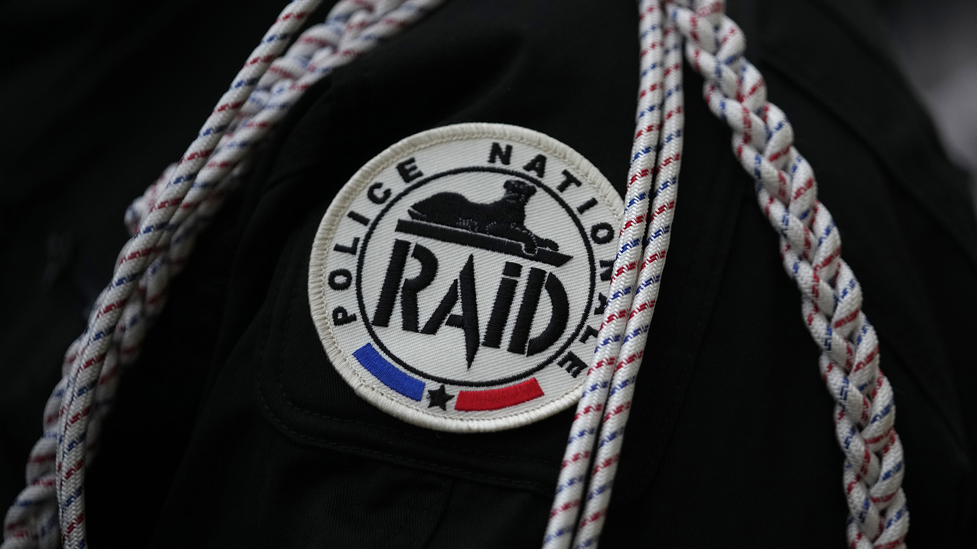 Un membre de l'unité d'élite de la police RAID (Recherche, Assistance, Intervention, Dissuasion) porte le logo de l'unité sur son uniforme lors d'une cérémonie au siège du RAID à Bièvres, au sud de Paris, vendredi 12 janvier 2024. 