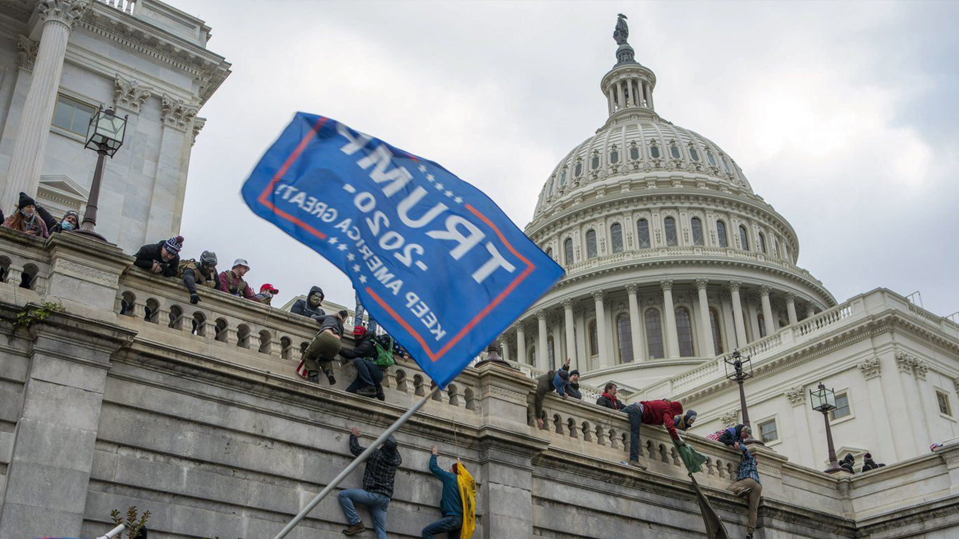 Des partisans du président Donald Trump escaladent le mur ouest du Capitole à Washington, le 6 janvier 2021.