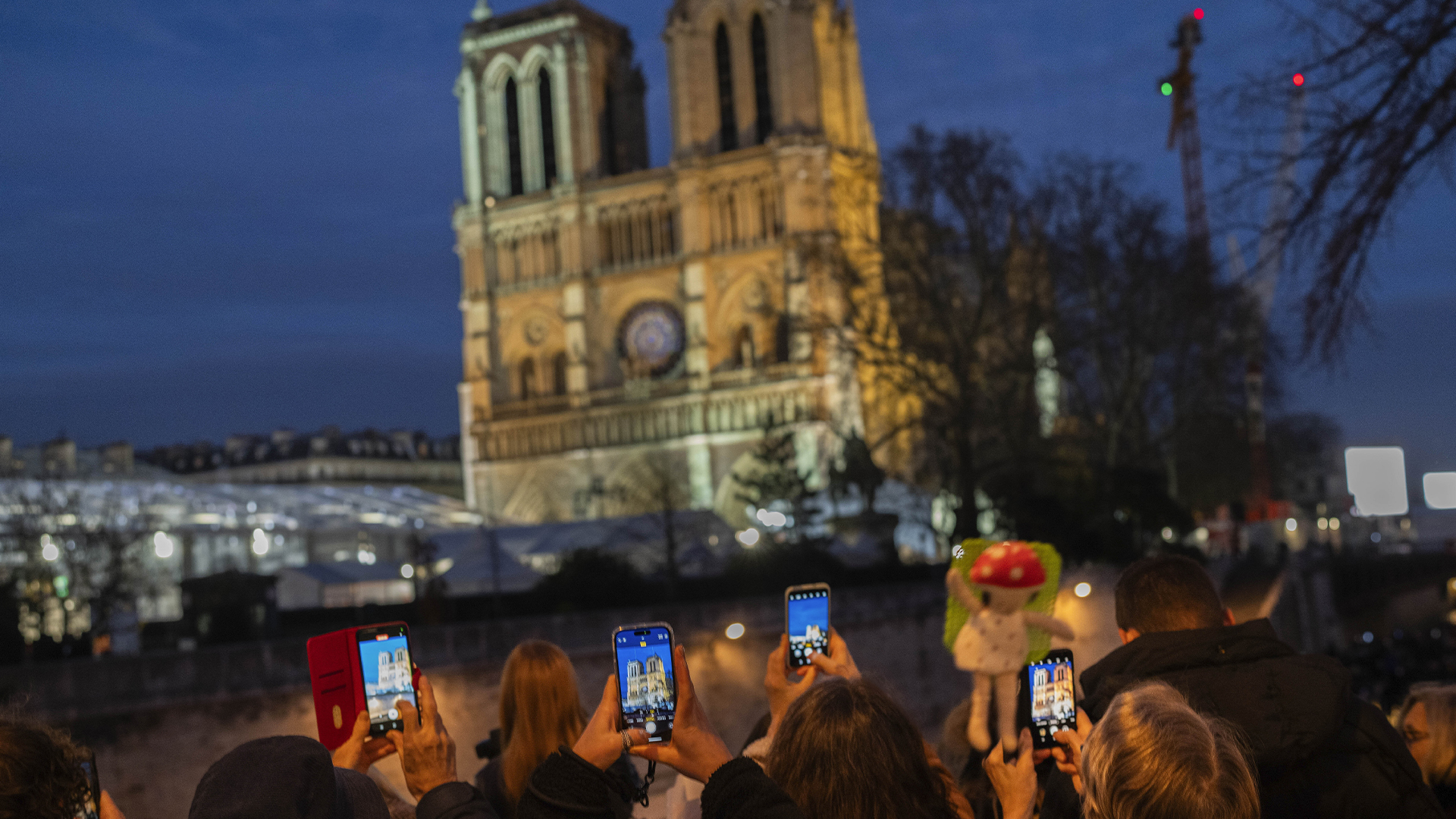 Des piétons prennent des clichés de la cathédrale Notre-Dame de Paris à la veille de sa réouverture dans la capitale française le vendredi 6 décembre 2024, cinq ans après le terrible incendie qui a ravagé le site emblématique en 2019.