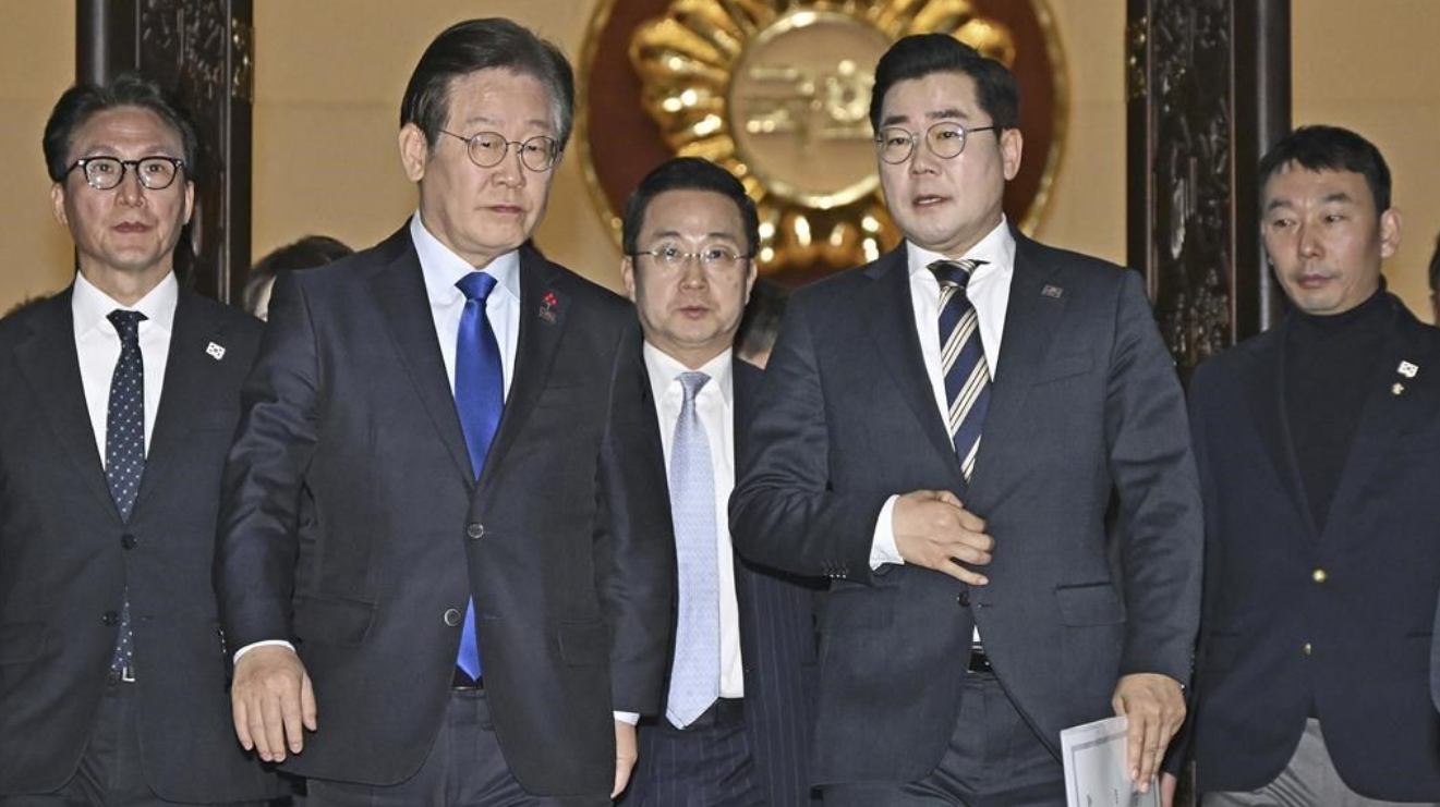 Le chef du Parti démocrate, principal parti d'opposition sud-coréen, Lee Jae-myung, à gauche, et son chef de file Park Chan-dae, à droite, quittent une salle de l'Assemblée nationale à Séoul après que le parlement sud-coréen a voté la destitution du président Yoon Suk Yeol, samedi 14 décembre 2024. 