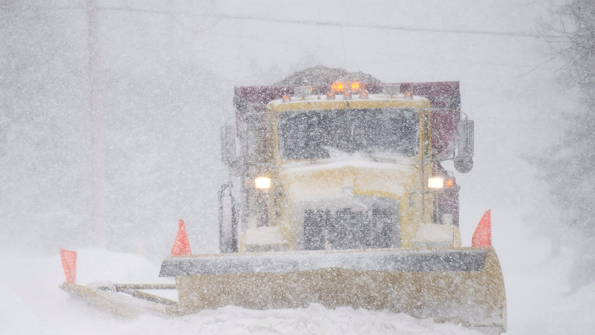 Un chasse-neige déblaie une rue lors d'une tempête de neige printanière près de Montréal, le samedi 22 mars 2014.