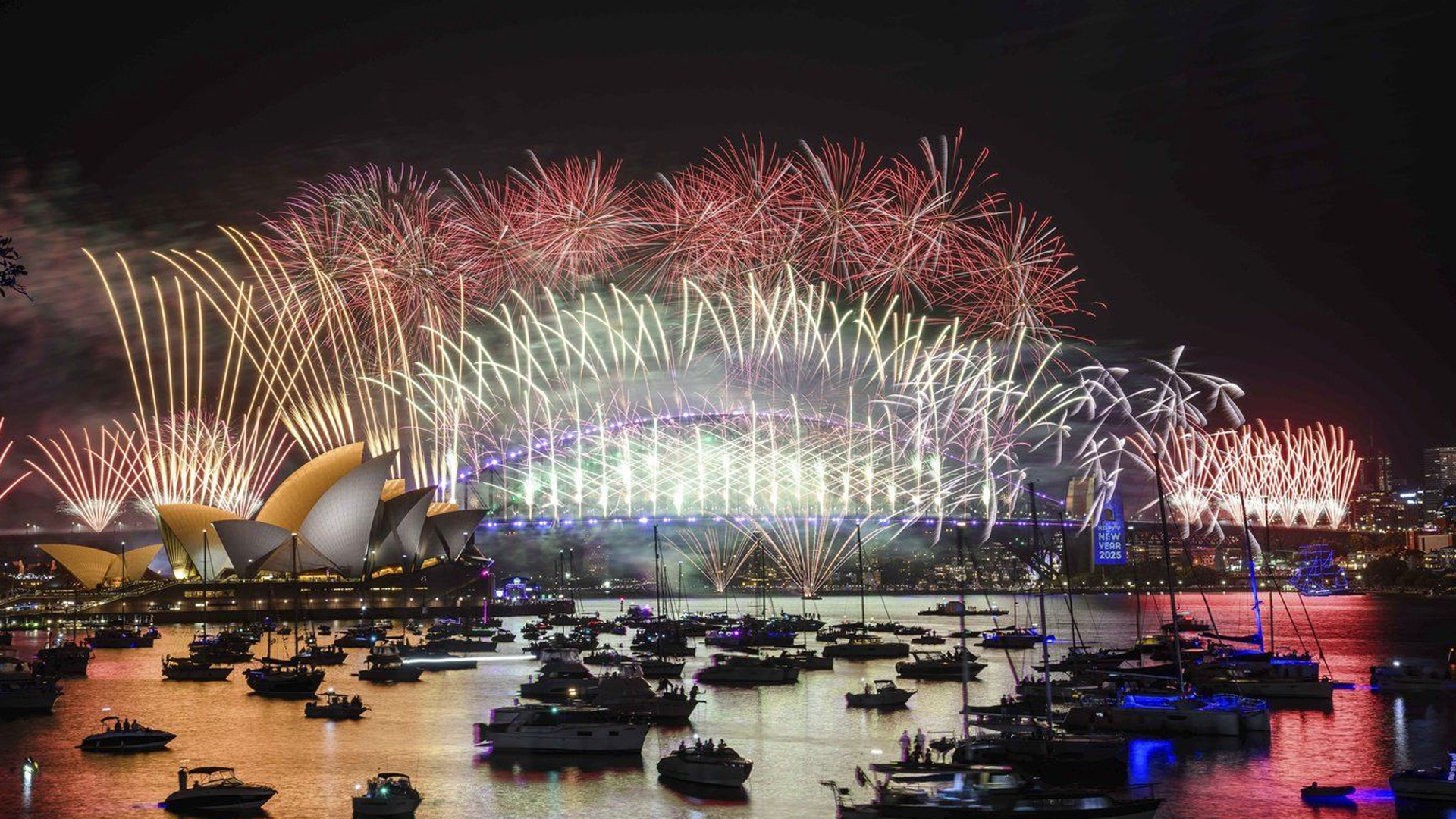 Des feux d'artifice explosent au-dessus de l'Opéra de Sydney et du Harbour Bridge pendant les célébrations du Nouvel An à Sydney, le mardi 31 décembre 2024. 