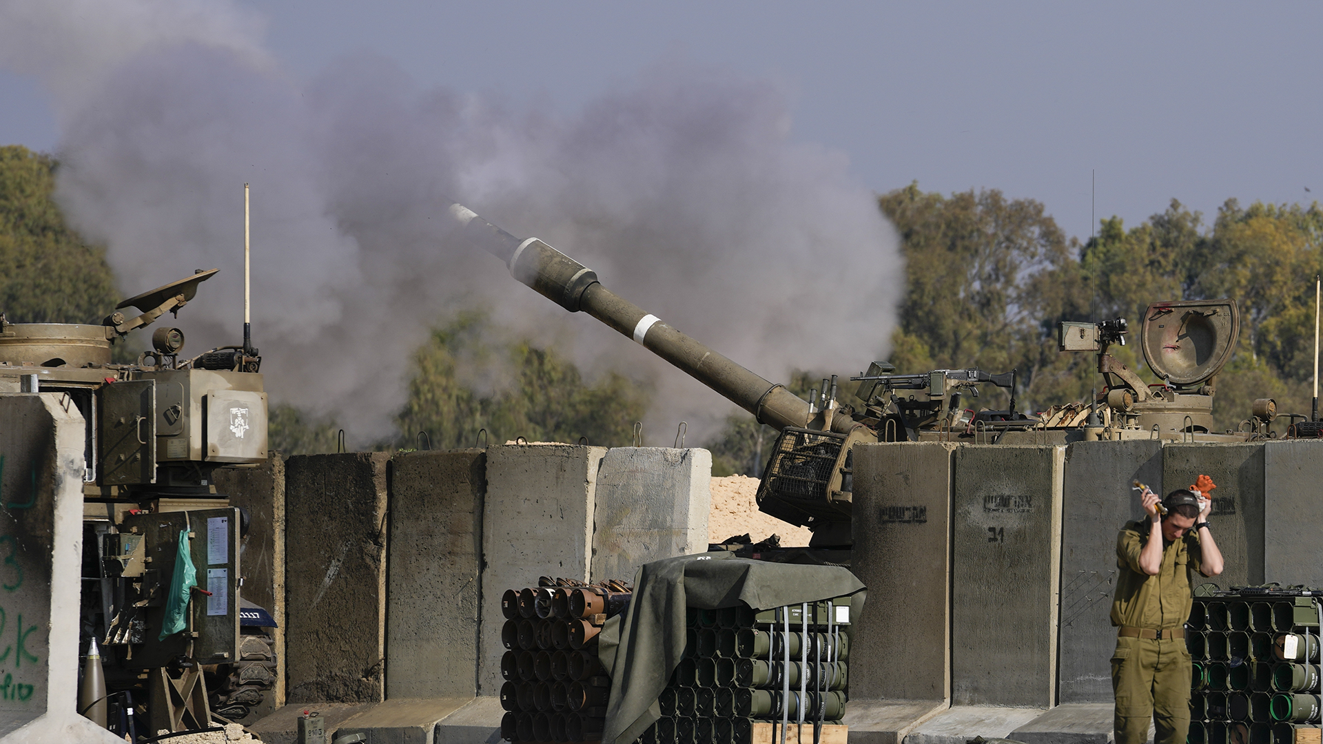 Un soldat israélien se bouche les oreilles alors qu'un artilleur tire sur la bande de Gaza depuis une position dans le sud d'Israël, jeudi 2 janvier 2025.