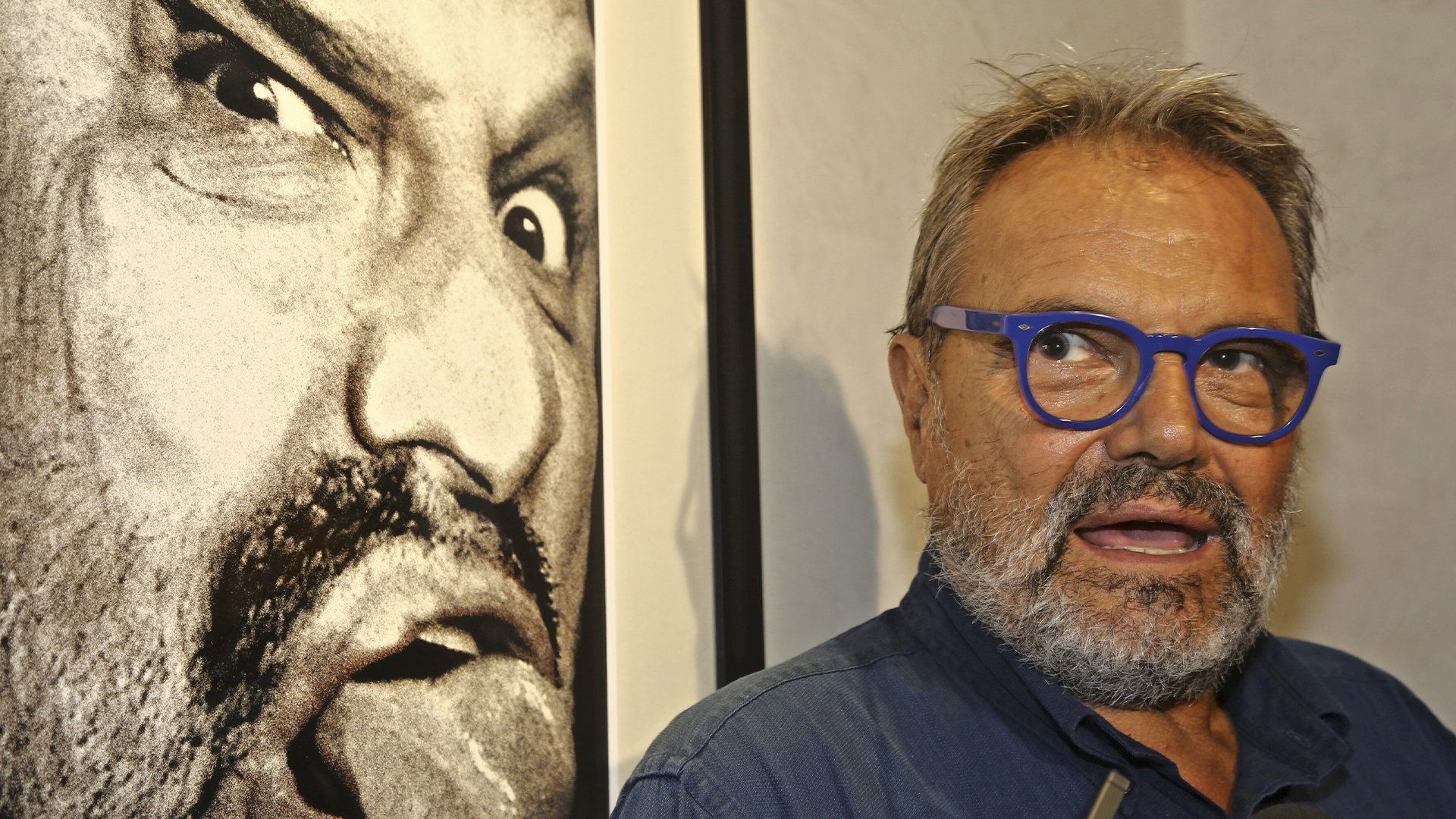 Le photographe italien Oliviero Toscani est photographié devant l'une de ses œuvres, un autoportrait, dans l'ancienne église de San Pier Scheraggio, à Florence, en Italie, le 7 septembre 2016.