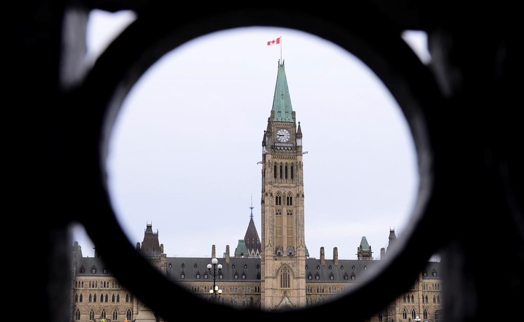 The Parliament Hill Peace Tower is framed in an iron fence on Wellington Street in Ottawa on Thursday, March 12, 2020. The federal government is asking Parliament to set aside $3 billion in anticipation of several out-of-court settlements with Indigenous people.THE CANADIAN PRESS/Sean Kilpatrick