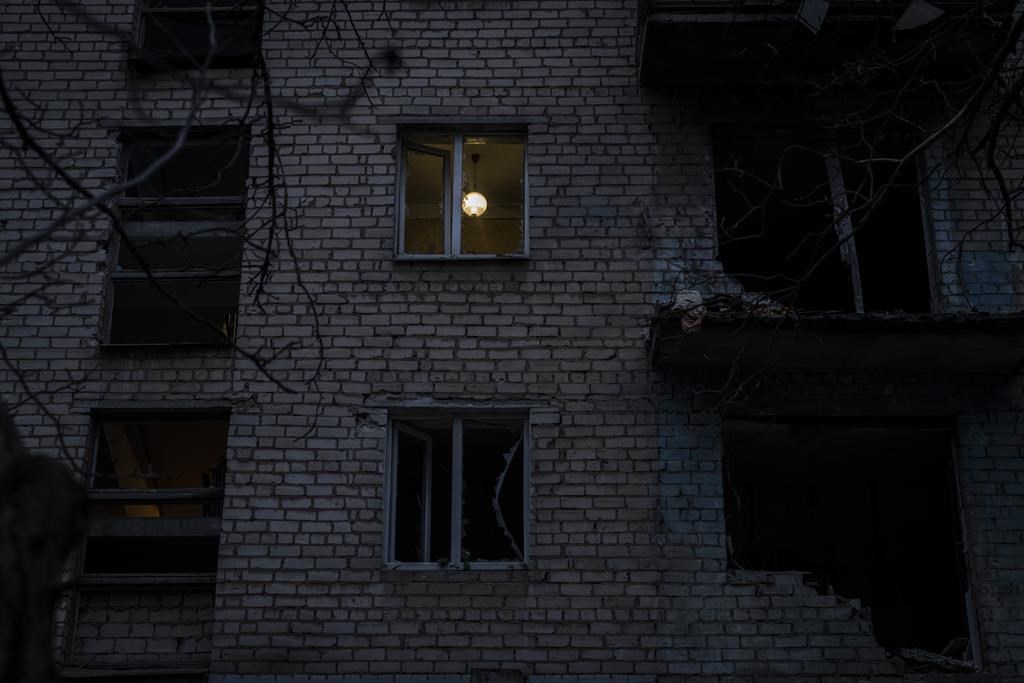 Une lampe illumine une pièce d'un bâtiment récemment endommagé lors d'une frappe russe dans la ville méridionale de Kherson, en Ukraine, le dimanche 27 novembre 2022. Des bombardements par les forces russes ont frappé plusieurs zones de l'est et du sud de l'Ukraine pendant la nuit alors que les équipes de services publics poursuivaient leur quête pour rétablir l'électricité, l'eau et le chauffage après les grèves généralisées de ces dernières semaines, ont annoncé dimanche des responsables.