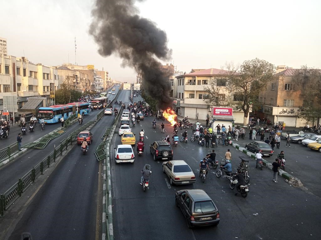 A motorcycle of Basij, Iranian paramilitary militia, is set on fire during a protest after a 22-year-old woman Mahsa Amini's death when she was detained by the morality police, in Tehran, Monday, Oct. 10, 2022 in this photo taken by an individual not employed by the Associated Press and obtained by the AP outside Iran. Canada is sanctioning more Iranian officials, including a senior military official spotted earlier this year at a Toronto-area gym. THE CANADIAN PRESS/AP-Middle East Images