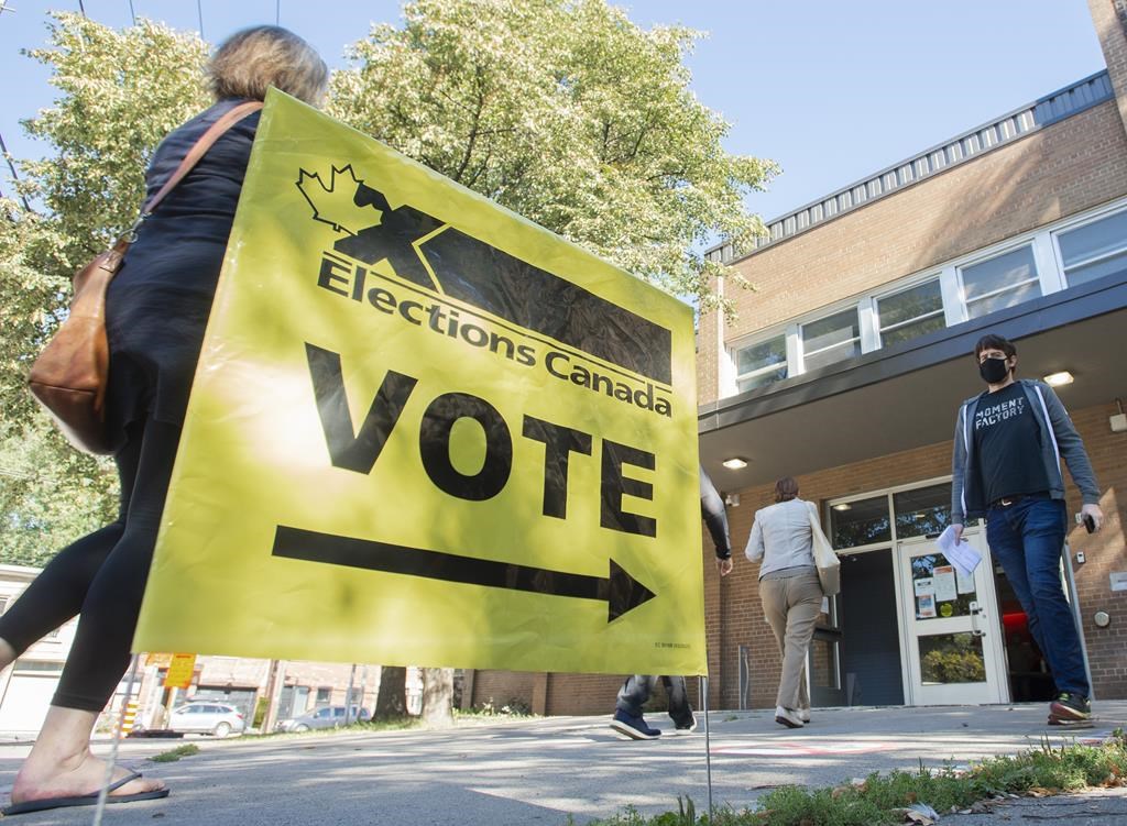 People arrive to cast their ballot on federal election day in Montreal, Monday, Sept. 20, 2021. A Parliamentary committee is set to decide whether or not it will expand its current study on foreign election interference to include more details about the 2021 federal election. THE CANADIAN PRESS/Graham Hughes