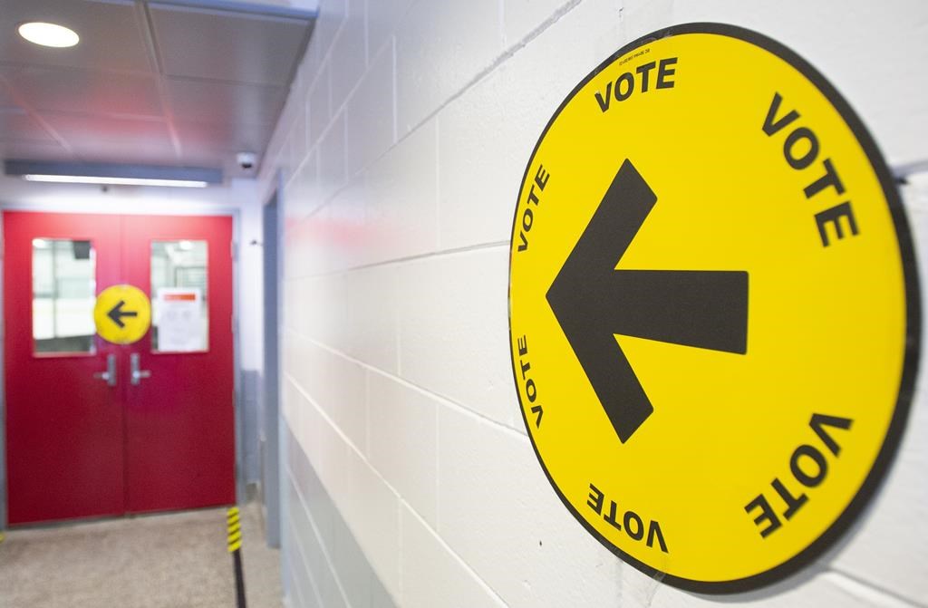 An arrow points to where people can go to cast their ballots on federal election day in Montreal, Monday, Sept. 20, 2021. More than a year after the Liberal government was re-elected, the independent panel report tasked with surveying foreign interference during the 2021 election has not yet been made public. THE CANADIAN PRESS/Graham Hughes