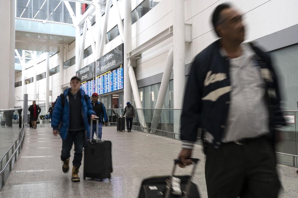 Passengers arrive at Pearson Airport in Mississauga, Ont. on Tuesday, March 14, 2023. The strike action by federal civil servants could draw out the wait time for air passenger complaints even further. THE CANADIAN PRESS/Chris Young