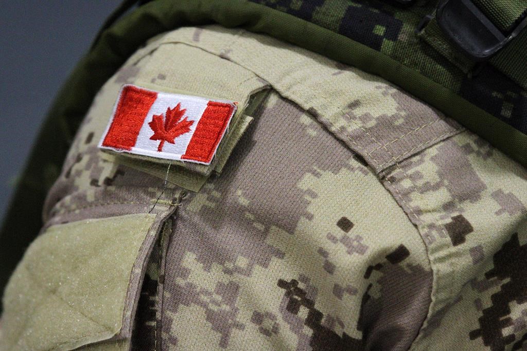 A Canadian flag sits on a Canadian Armed Forces member's uniform in Trenton, Ont., Oct. 16, 2014. THE CANADIAN PRESS/Lars Hagberg