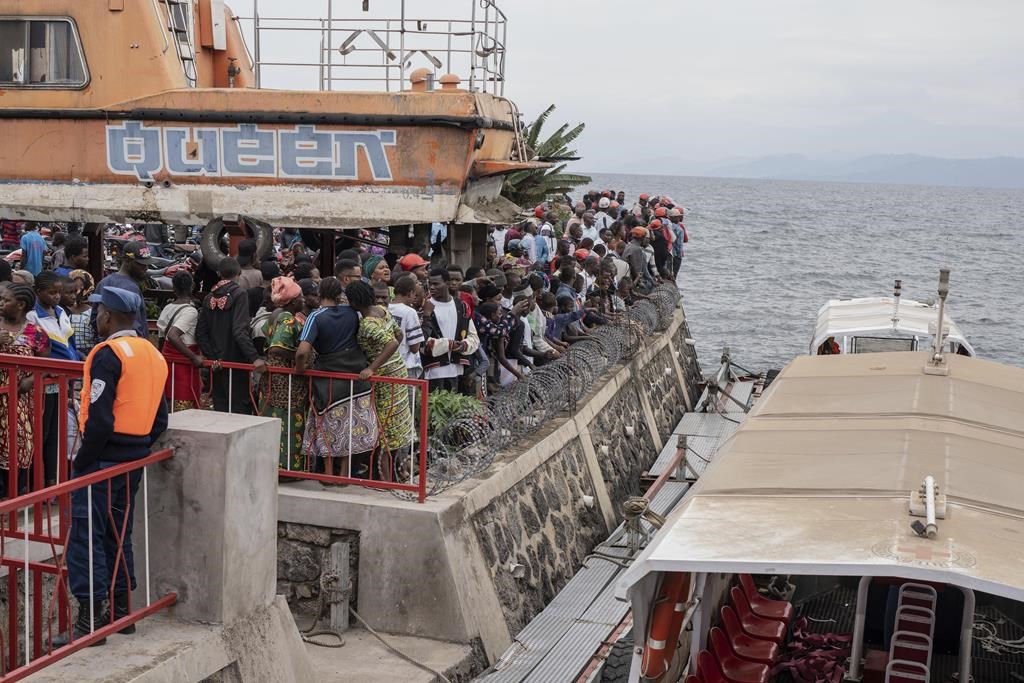 People gather at the port of Goma, Democratic Republic of Congo, after a ferry carrying hundreds capsized on arrival Thursday, Oct. 3, 2024. (AP Photo/Moses Sawasawa)