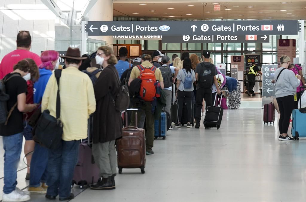 People line up before entering the security zone at Pearson International Airport in Toronto on Friday, August 5, 2022. Supreme Court upholds rules on passenger compensation in victory for air travellers. The Supreme Court of Canada says it will uphold rules that bolster compensation for air passengers subjected to delayed flights and damaged luggage.THE CANADIAN PRESS/Nathan Denette