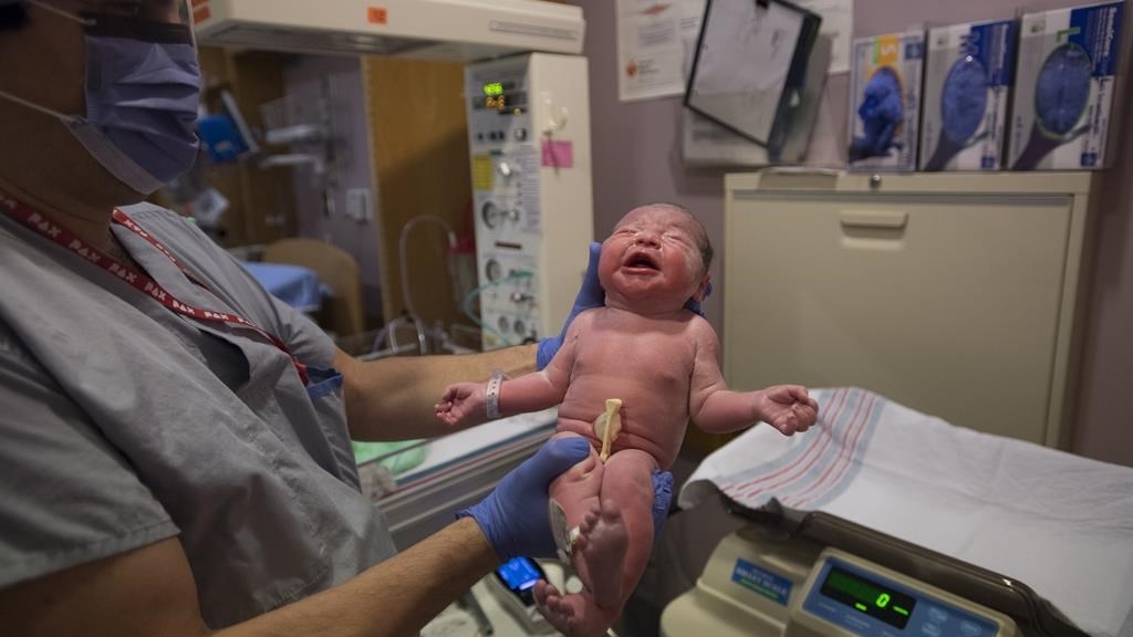 Le pédiatre Rod Rassekh examine la petite fille de Kate et Brian Chongs, Adelynn Susandrea Chong, juste après l'accouchement à l'hôpital St. Paul dans le centre-ville de Vancouver.