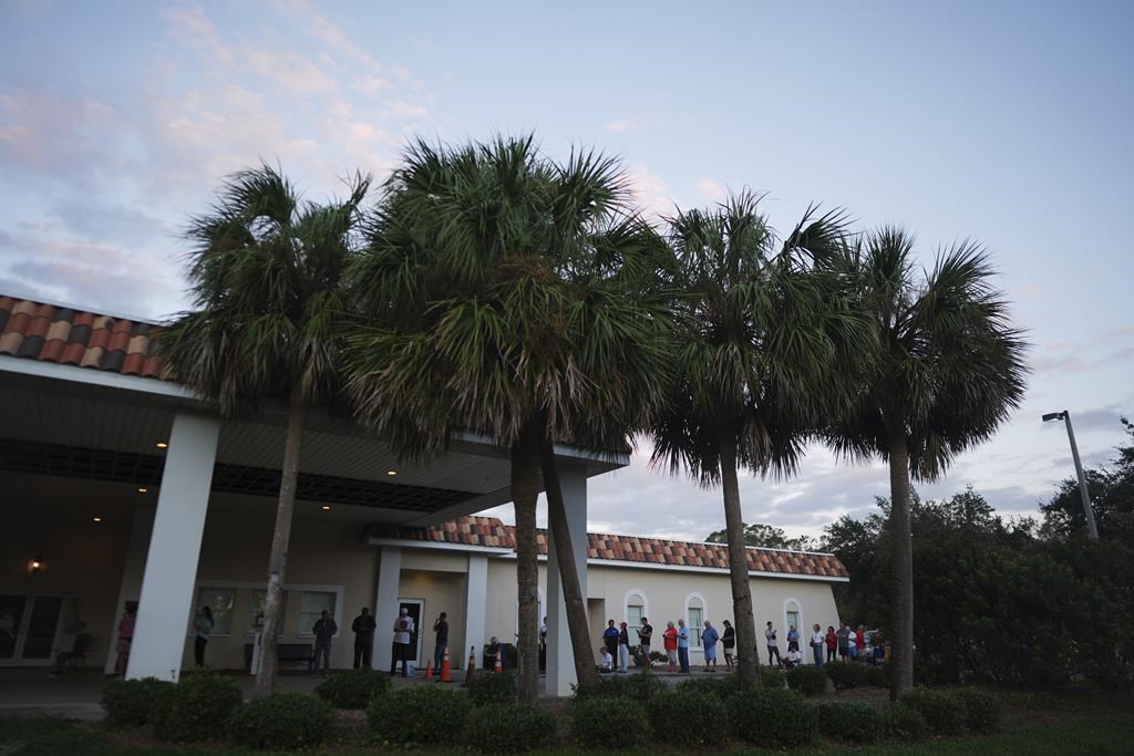 Voters wait in line to cast their ballots outside a polling place at Pasadena Community Church, at sunrise on Election Day, just before the opening of the polls, Tuesday, Nov. 5, 2024, in St. Petersburg, Fla. (AP Photo/Rebecca Blackwell)