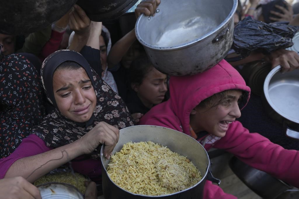 Des filles palestiniennes luttent pour obtenir de la nourriture dans un centre de distribution à Khan Younis, dans la bande de Gaza, le vendredi 6 décembre 2024.