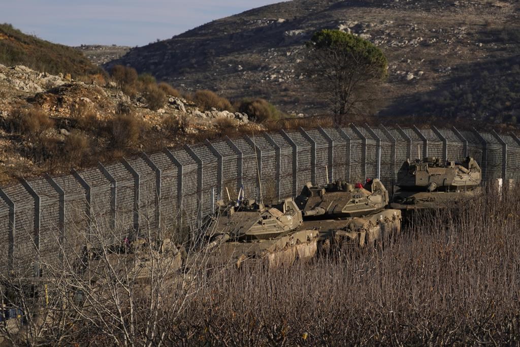 Des véhicules blindés israéliens stationnent le long de la ligne alpha qui sépare les hauteurs du Golan annexées par Israël de la Syrie, le 8 décembre 2024. 