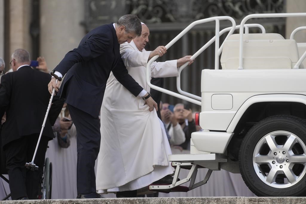 Pope Francis attempts to get on his car as he leaves at the end of the weekly general audience in St. Peter's Square at the Vatican, Wednesday, March 6, 2024. (AP Photo/Gregorio Borgia)