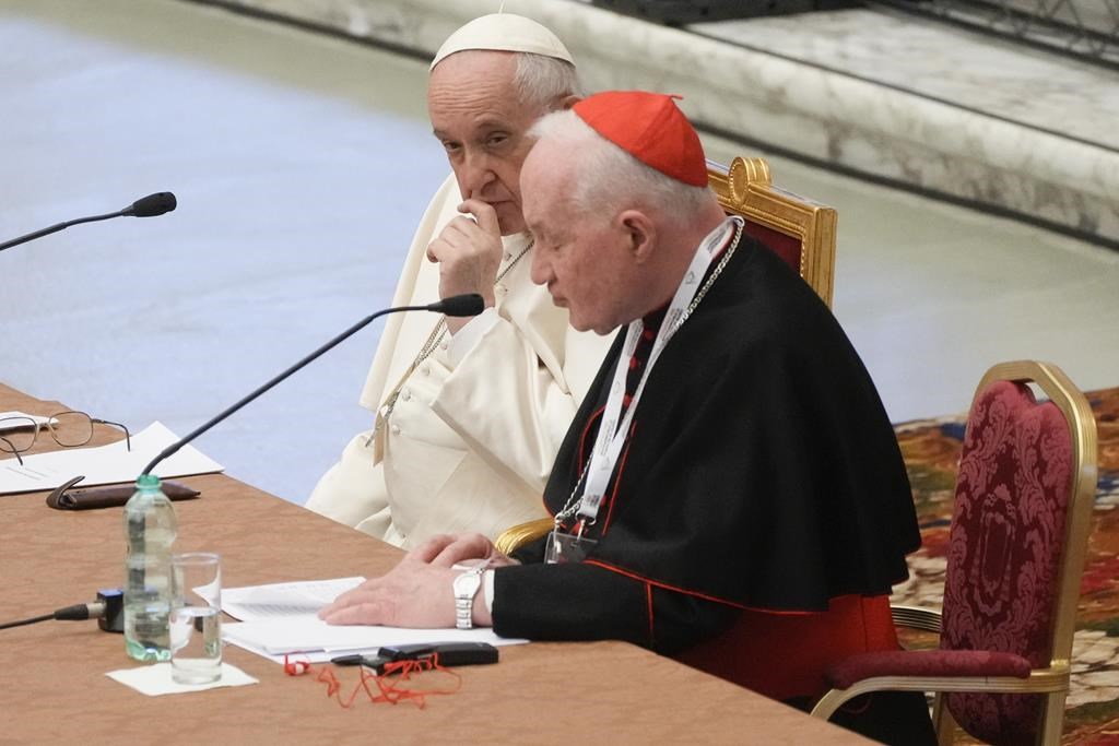 Le pape François, à gauche, écoute le discours d'ouverture du cardinal Marc Ouellet lors de l'ouverture d'un symposium de trois jours sur les vocations dans la salle Paul VI au Vatican, jeudi 17 février 2022. 