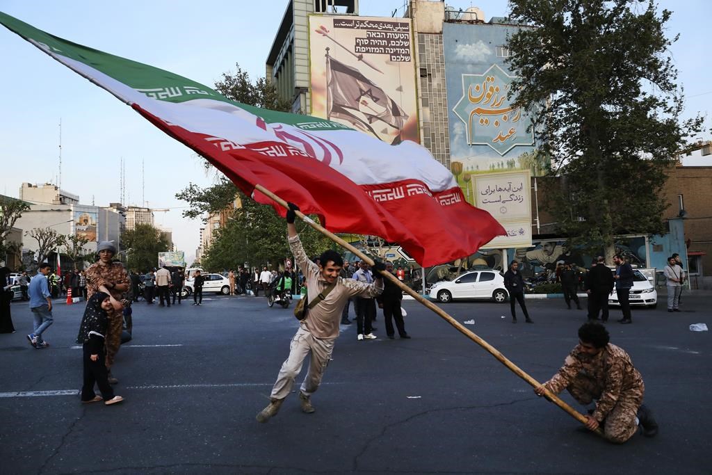 Des manifestants agitent un drapeau de l'Iran lors d'une démonstration anti-Israël à Téhéran en avril 2024.