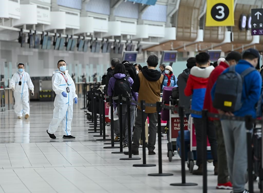 People line up and check in for an international flight at Pearson International Airport during the COVID-19 pandemic in Toronto on Wednesday, Oct. 14, 2020. The federal government and a consumer rights advocate are squaring off in court over whether regulators misled passengers by encouraging travel credit rather than refunds at the onset of the COVID-19 pandemic. THE CANADIAN PRESS/Nathan Denette