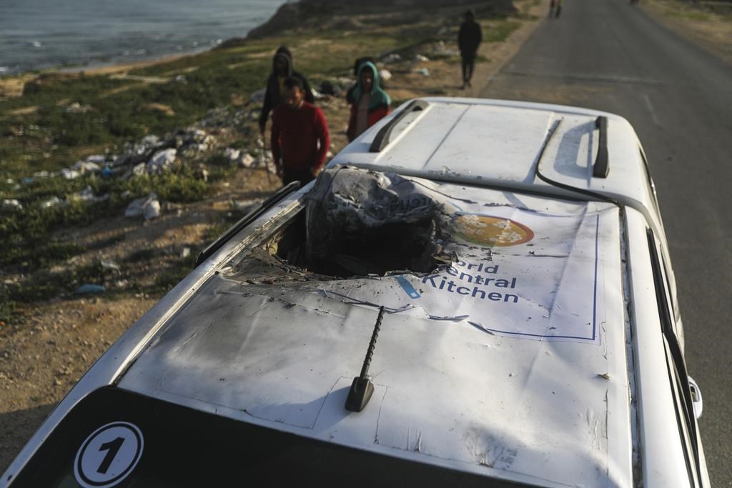 Des Palestiniens inspectent un véhicule portant le logo de la World Central Kitchen, détruit par une frappe aérienne israélienne à Deir al Balah, dans la bande de Gaza, le mardi 2 avril 2024. Une série de frappes aériennes a tué sept travailleurs humanitaires de l'organisation caritative internationale, ce qui l'a amenée à suspendre mardi la livraison d'une aide alimentaire vitale à Gaza.