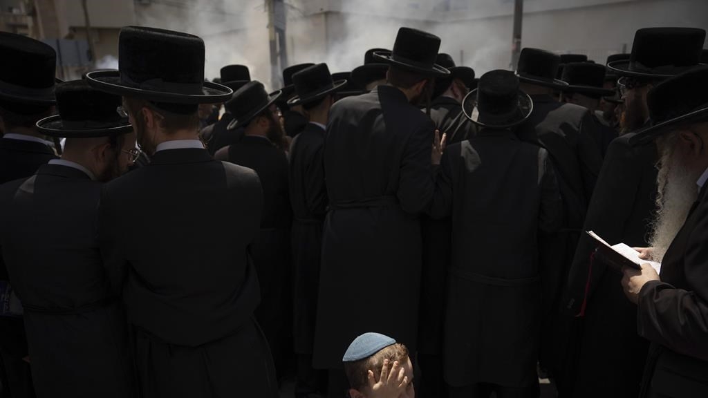 Des hommes et des enfants juifs orthodoxes brûlent des aliments au levain en préparation finale pour la fête de Pâque dans la ville juive ultra-orthodoxe de Bnei Brak, près de Tel Aviv, en Israël, le 22 avril 2024. 