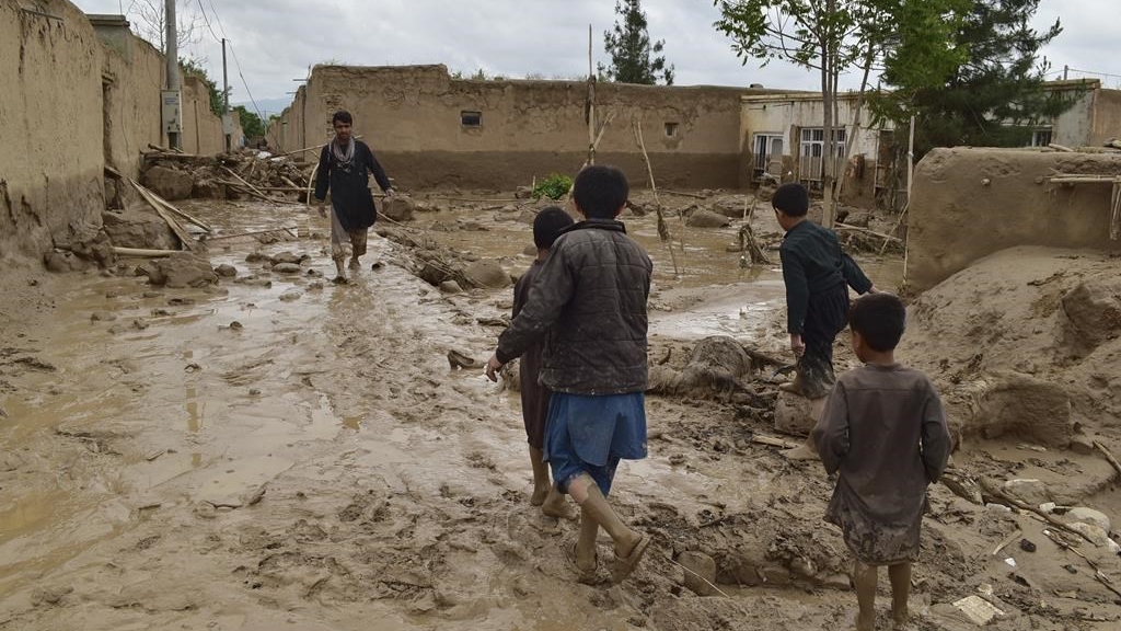 Des personnes marchent près de leurs maisons endommagées par de fortes inondations dans la province de Baghlan, dans le nord de l'Afghanistan, le 11 mai 2024.